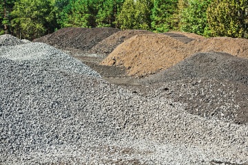 piles of gravel and mixed sand on construction site in forest